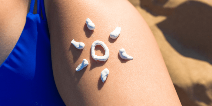 crème solaire en forme de soleil sur la cuisse d'une personne